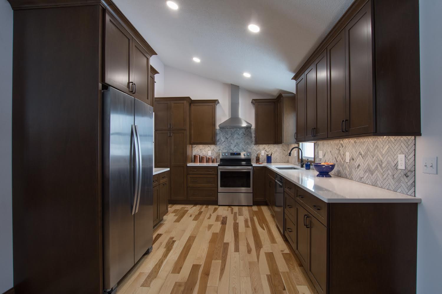 Kitchen remodel with dark cabinetry and herringbone backsplash